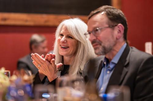 Close-up photo of Angela Eberts and Ron Temple; Angela smiles and applauds