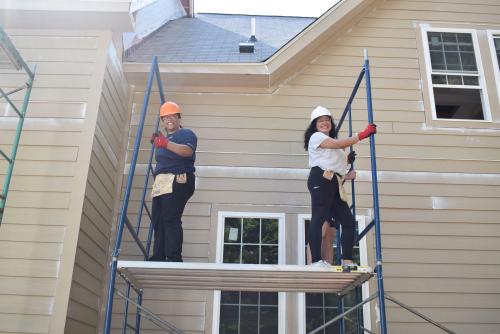 Two Sloan Scholars gaining hands-on experience working on houses with Habitat for Humanity