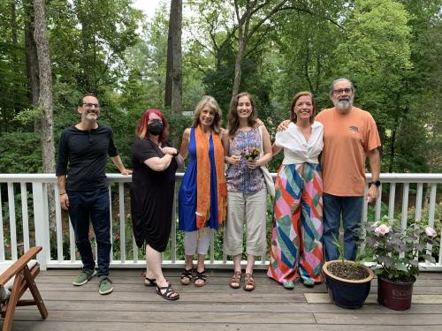 Group photo of six individuals, including Dr. Quirici in the middle, against an outdoor, woodsy backdrop.