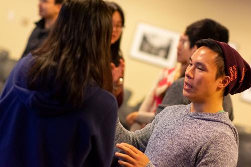 Student in a cap talking to a group of other students